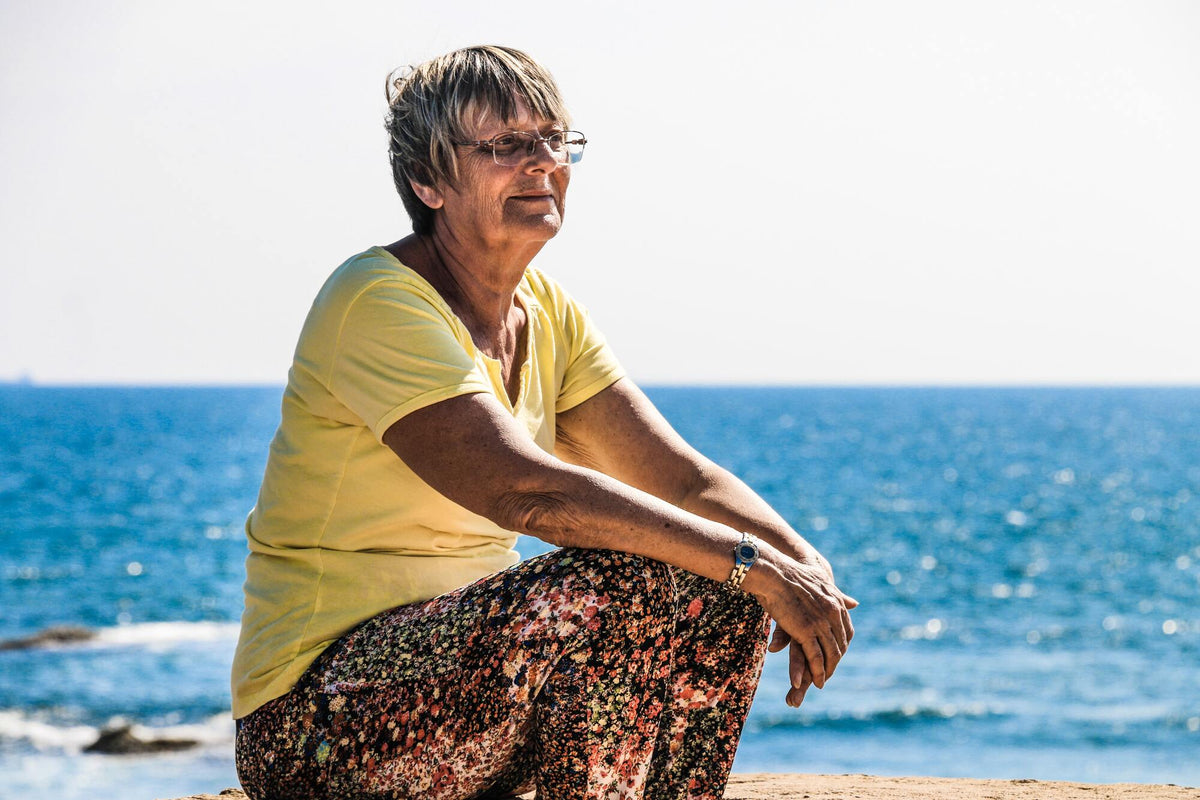 Mamie à la plage devant la mer