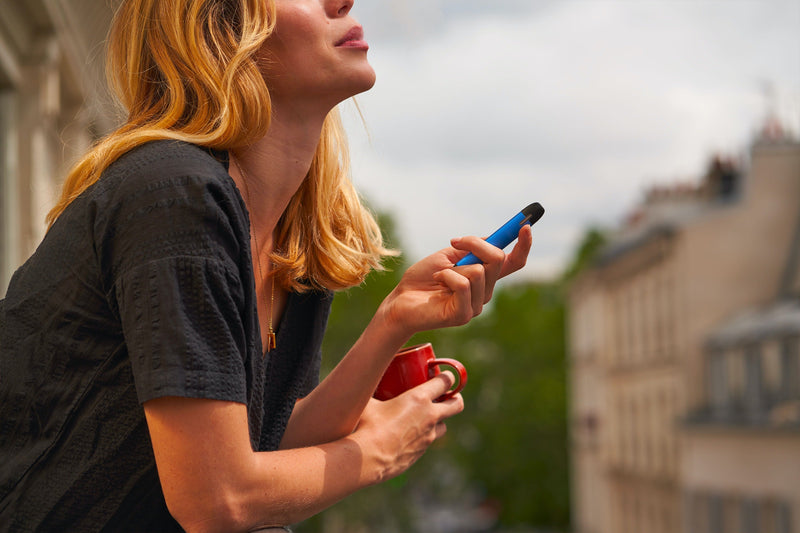 Femme qui vapote sur son balcon